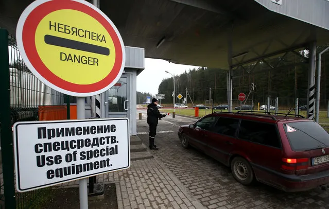 A Belarussian border guard stops a car at a checkpoint Kotlovka at the border between Belarus and Lithuania, near the village of Kotlovka, Belarus, November 22, 2016. (Photo by Vasily Fedosenko/Reuters)