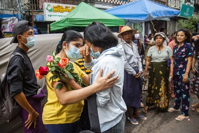 An anti-coup student protester is welcomed home with flowers by the residents of her neighborhood after being released from jail, Friday, March 26, 2021, in Yangon, Myanmar. (Photo by AP Photo/Stringer)