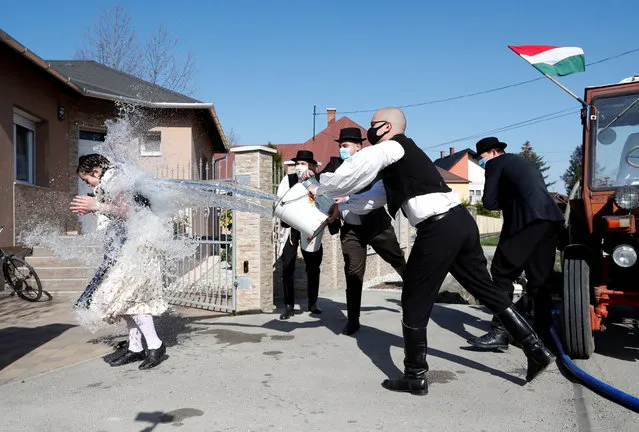 Members of the Hungarian dance and folk art ensemble Marcal throw water at a woman as part of traditional Easter celebrations in Gyor-Menfocsanak, Hungary, April 5, 2021. (Photo by Bernadett Szabo/Reuters)