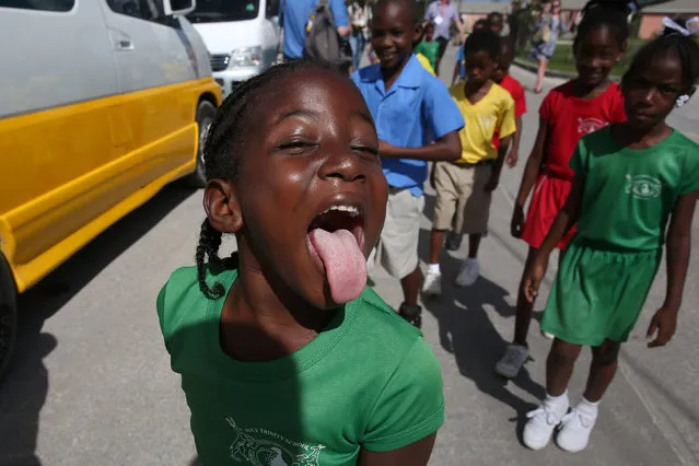 A child makes a face for the camera as she walks down a road after Prince Harry visited Holy Trinity Primary school during his official visit to Codrington, Barbuda, November 22, 2016. (Photo by Carlo Allegri/Reuters)