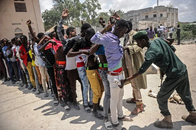A Somali soldier checks a man at the entrance before a handover ceremony as African Union Mission to Somalia (AMISOM) leaves from the Mogadishu stadium in Mogadishu, Somalia, on August 28, 2018. The Mogadishu stadium has been occupied as a base for AMISOM since 2011 and returned as a public ground as it used to be. (Photo by Mohamed Abdiwahab/AFP Photo)