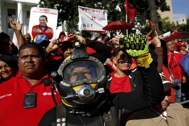 A technical diver and fellow workers from the Venezuelan state oil company PDVSA attend a meeting with Venezuela's President Nicolas Maduro outside Miraflores Palace in Caracas January 12, 2016. Venezuela's PDVSA is still mulling a potential bond refinancing, its president said on Tuesday, referring to a proposal floated by the state oil company to seek an extension of payment for bonds maturing in 2016 and 2017. (Photo by Carlos Garcia Rawlins/Reuters)