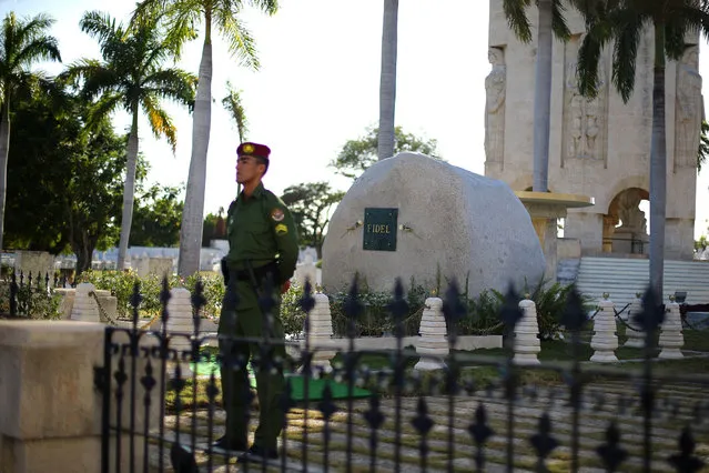 A soldier stands guard next to a granite boulder where Cuba's former President Fidel Castro's ashes were encased during a private ceremony, and near the mausoleum of Cuba's independence hero Jose Marti, at the Santa Ifigenia Cemetery, in Santiago de Cuba, December 4, 2016. (Photo by Ivan Alvarado/Reuters)