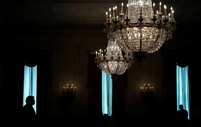 President Trump is silhouetted in a window of the East Room as he participates in a ceremony awarding a Medal of Honor posthumously to Air Force Technical Sergeant John A. Chapman at the White House on August 22, 2018. (Photo by Leah Millis/Reuters)