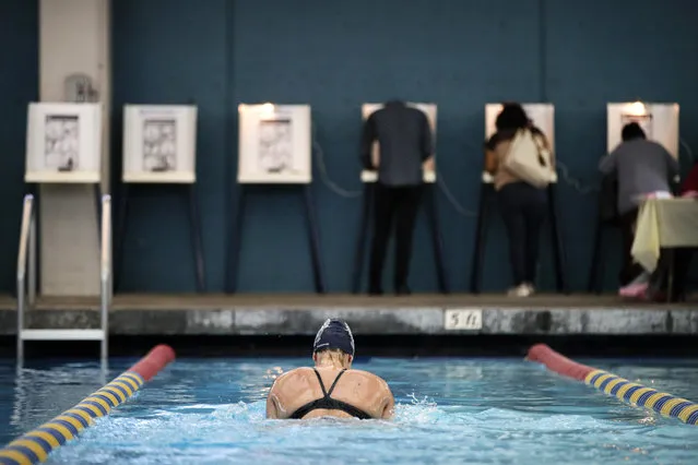 Sarah Salem, 34, swims as voters cast their ballots at Echo Deep Pool Tuesday, November 6, 2018, in Los Angeles. (Photo by Jae C. Hong/AP Photo)