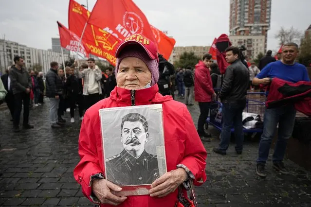 An elderly woman holds a portrait of aSoviet leader Josef Stalin as other people gather to march with flowers and portraits of those who were killed during the 1993 bloody clashes between government forces and supporters of the rebellious parliament during a rally marking the 30th anniversary of the events in Moscow, Russia, Wednesday, October 4, 2023. (Photo by Alexander Zemlianichenko/AP Photo)
