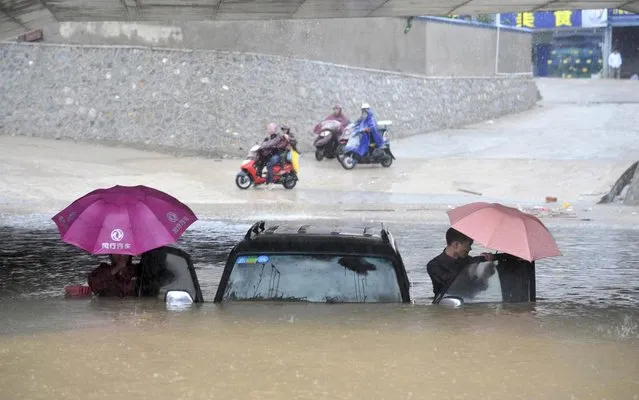 People get out of a stranded car at a flooded underpass amid heavy rainfalls under the influence of Typhoon Haiyan, in Nanning, Guangxi Zhuang autonomous region November 11, 2013. Rainstorms brought by the typhoon hit the south China region on Sunday and Monday, killing at least four, with seven people still missing, according to Xinhua News Agency. (Photo by Reuters/China Daily)