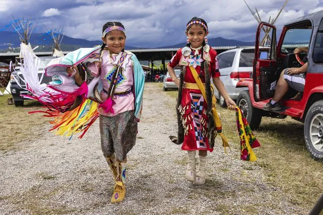 The dancers Harmony Kickingwoman, 6, left, and Braylin Kickingwoman, 7, whose family travels every weekend from April to September to compete at powwows, at the 122nd annual Arlee Celebration powwow in Arlee, Mont., July 4, 2022. The celebration – a mix of dance and drum competitions, traditional ceremonies and games – serves as a space for multiple tribes to compete, eat traditional foods and visit with relatives and old friends. (Photo by Tailyr Irvine/The New York Times)