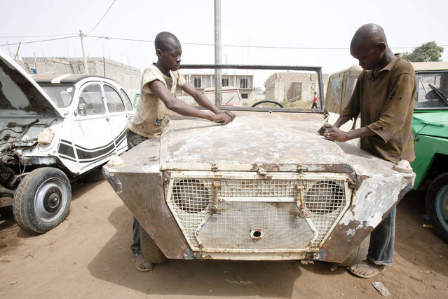 Two boys work on a car in Babi Kouakou's car repair garage in Bouake, Ivory Coast February 9, 2016. (Photo by Thierry Gouegnon/Reuters)