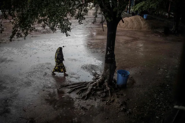 A woman arrives under torrential rain to vote during general elections in Kinshasa on December 30, 2018. Voters in the Democratic Republic of Congo went to the polls on December 30 in elections that will shape the future of their vast, troubled country, amid fears that violence could overshadow the ballot. (Photo by Marco Longari/AFP Photo)