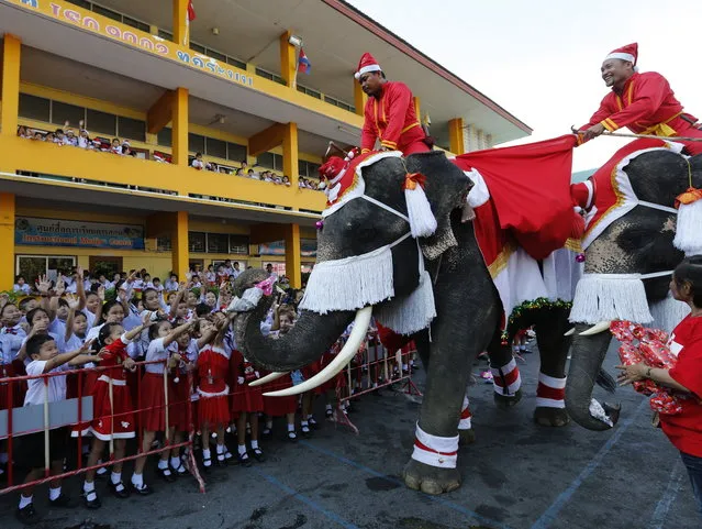 Thai elephants and mahouts, all dressed as Santa Claus, entertain students during Christmas celebrations at a school in the world heritage city of Ayutthaya, north of Bangkok, Thailand, 24 December 2018. The annual event is held every year for to celebrate the upcoming Christmas festive season and promote tourism in Ayutthaya. (Photo by Narong Sangnak/EPA/EFE)