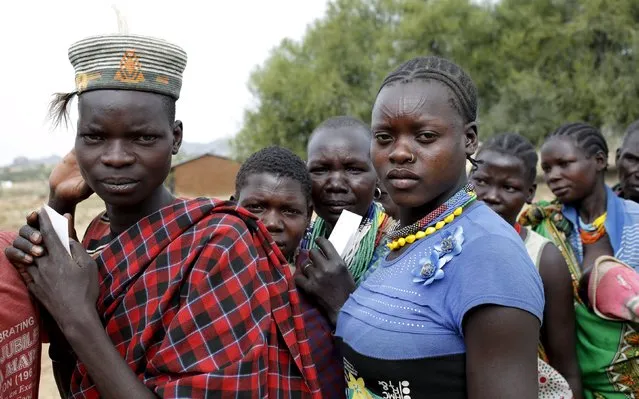 People from Karamojong tribe wait in line to vote at a polling station during the presidential elections in a village near town of Kaabong in Karamoja region, Uganda, February 18, 2016. (Photo by Goran Tomasevic/Reuters)