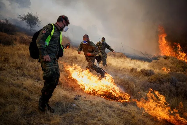 Volunteers try to extinguish a wildfire burning in the village of Markati, near Athens, Greece, August 16, 2021. (Photo by Alkis Konstantinidis/Reuters)
