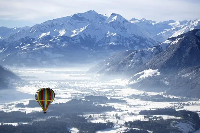A hot air balloon makes his way above Zell am See, Austria, Tuesday, February 5, 2019. (Photo by Matthias Schrader/AP Photo)