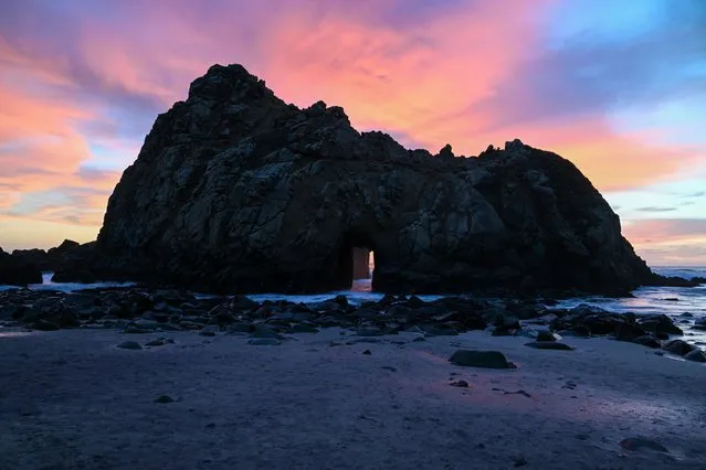 A sunray passes through Keyhole Arch during sunset at Pfeiffer Beach in Big Sur, California, United States on December 24, 2023. (Photo by Tayfun Coskun/Anadolu via Getty Images)
