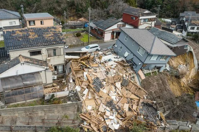 This aerial photo shows damaged and destroyed homes along a street in Wajima, Ishikawa prefecture on January 2, 2024, a day after a major 7.5 magnitude earthquake struck the Noto region in Ishikawa prefecture. Japanese rescuers battled against the clock and powerful aftershocks on January 2 to find survivors of a major earthquake that struck on New Year's Day, killing at least six people and leaving a trail of destruction. (Photo by Fred Mery/AFP Photo)