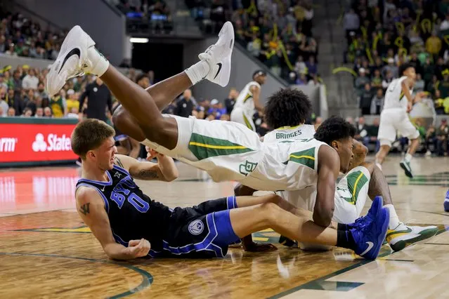 Baylor center Yves Missi, top, is brought down by BYU forward Noah Waterman, left, during the second half of an NCAA college basketball game Tuesday, January 9, 2024, in Waco, Texas. Baylor won 81-72. (Photo by Gareth Patterson/AP Photo)