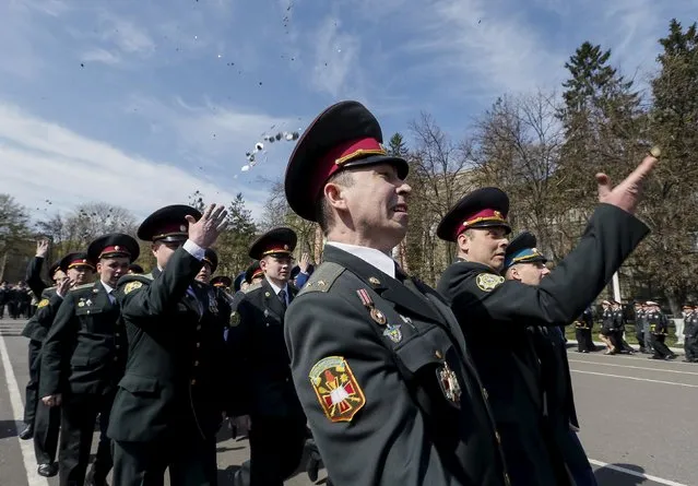 Ukrainian army officers throw coins after a graduation ceremony at the National University of Defence of Ukraine in Kiev April 24, 2015. (Photo by Gleb Garanich/Reuters)
