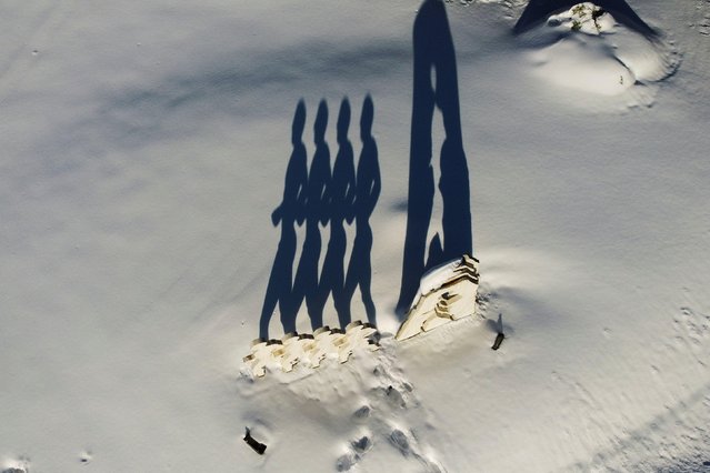 The sculpture “Runners” by Greek sculptor Theodoros Papagiannis casts a shadow on the snow following heavy snowfall in Dionysos, Greece, February 17, 2021. Picture taken with a drone. (Photo by Alkis Konstantinidis/Reuters)