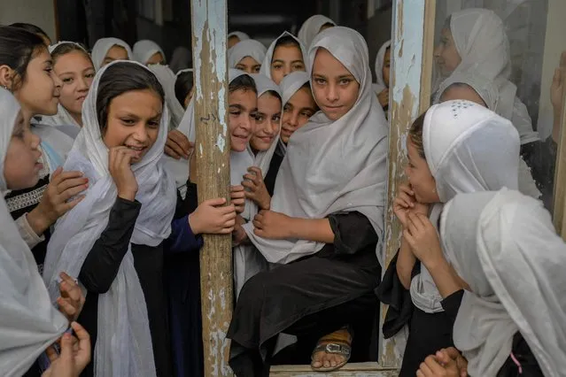 Afghan girls are pictured as they step out of their respective classes, in a school in Kandahar on September 26, 2021. (Photo by Bulent Kilic/AFP Photo)