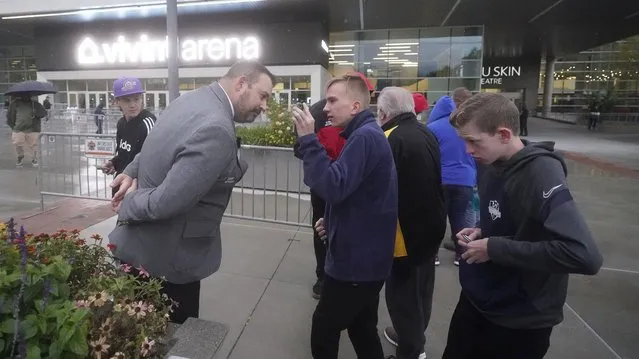 Utah Jazz security, left, looks for proof of vaccination or a negative test from fans before attending a preseason NBA basketball game Monday, October 11, 2021, in Salt Lake City. In Utah, the NBA's Jazz is making its employees get vaccinated. It is also requiring fans at games to show proof of vaccination or a negative COVID test. So far, just a few ticket refunds have been needed, and the season opener is expected to be sold out by next week, said Jazz spokesman Frank Zang.  (Photo by Rick Bowmer/AP Photo)