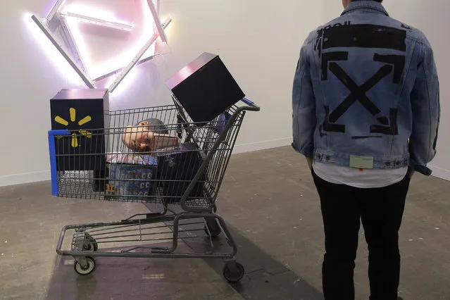 In this Wednesday, March 27, 2019, file photo, a visitor looks at an artwork “In Stock (Walmart Worker's Head)” created by American artist Josh Kline at Art Basel in Hong Kong. Art Basel, one of the world's most prestigious modern and contemporary art exhibitions, returned to Hong Kong in its seventh edition. The prestige art fair is hosting 242 galleries from 35 countries and territories. (Photo by Kin Cheung/AP Photo)