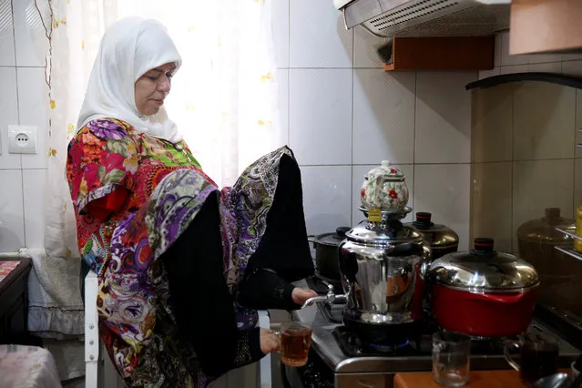 In this picture taken on Thursday, January 28, 2015, Zohreh Etezadossaltaneh uses her feet to pour tea at her home, in Tehran, Iran. Etezadossaltaneh was born without arms. (Photo by Ebrahim Noroozi/AP Photo)