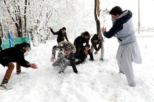Afghan men play with snowballs in Kabul on February 5, 2017. Avalanches and freezing weather have killed more than 20 people in different areas of Afghanistan, officials said on February 4, as rescuers worked to save scores still trapped under the snow. (Photo by Shah Marai/AFP Photo)