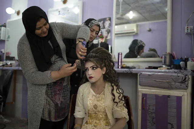 Shahad Ahmed Abed gets her hair done in a salon in Khazer for her wedding on Thursday, February 16, 2017. (Photo by Bram Janssen/AP Photo)