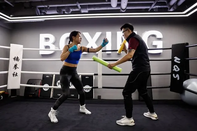 Gym owner Xie Lili (R) coaches a female member during a fitness boxing session at the Nan Boxing Gym in Beijing, China on February 28, 2024. (Photo by Tingshu Wang/Reuters)