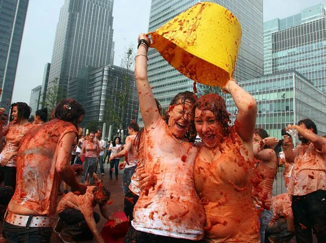 People throw tomatoes during Mission Deli Wraps's re-creation of the famous Spanish tomato-throwing festival, La Tomatina, at Canary Wharf, central London, on September 25, 2013. (Photo by Geoff Caddick/PA Wire)