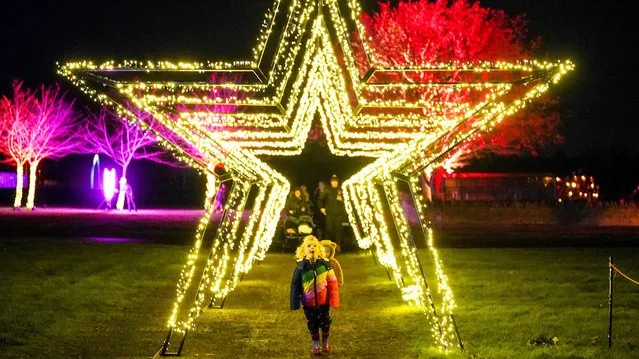 Visitors explore the outdoor light trail at Winter Glow, at Three Counties Showground in Malvern, Worcestershire, United Kingdom on Monday, December 6, 2021. (Photo by Jacob King/PA Images via Getty Images)