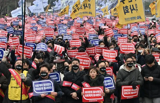 Doctors hold up placards reading “Opposition to the increase in medical schools” during a rally against the government's plan to raise the annual enrolment quota at medical schools, in Seoul on March 3, 2024. (Photo by Jung Yeon-Je/AFP Photo)