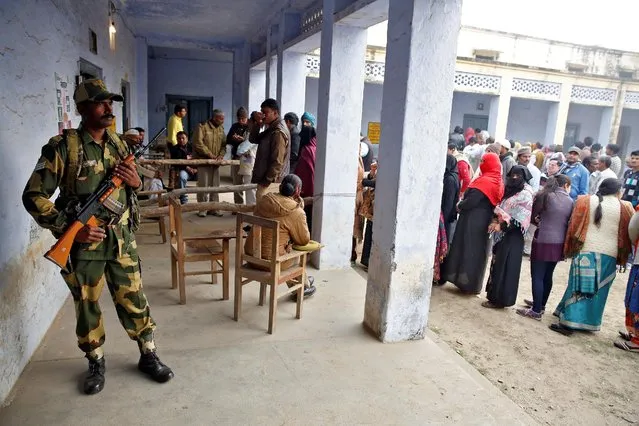 A soldier looks on as people queue to vote during the state assembly election, in the town of Deoband, in the state of Uttar Pradesh, India, February 15, 2017. (Photo by Cathal McNaughton/Reuters)