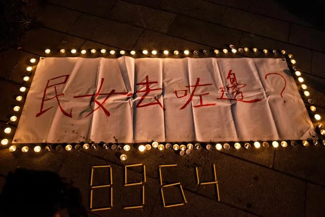 A banner with the slogan “Where is the Goddess of Democracy” and candles that form the number “8964”, which is the date of Beijing's 1989 crackdown on Tiananmen Square, is placed at the site of the “Goddess of Democracy” statue after it was removed from the Chinese University of Hong Kong on December 24, 2021. (Photo by Bertha Wang/AFP Photo)