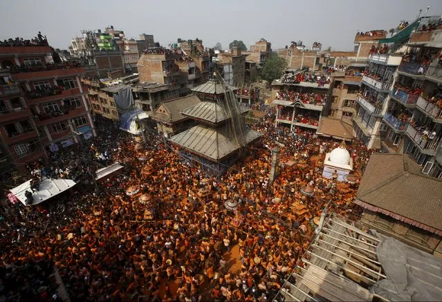 Devotees covered in vermilion powder carry chariots as they circle the Balkumari Temple (C) during the “Sindoor Jatra” vermillion powder festival at Thimi, in Bhaktapur, Nepal, April 14, 2016. (Photo by Navesh Chitrakar/Reuters)