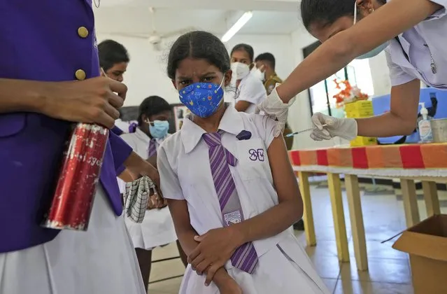 A Sri Lankan school student reacts as she receives her first COVID-19 vaccine from a health worker in Colombo, Sri Lanka, Friday, January 7, 2022. Sri Lankan health authorities starting to inoculate the children in the age group of 12 to 15 in it’s latest effort to contain the spreading of COVID-19 as the island nation’s top medical specialists warned of a massive wave of infection driven by the Omicron variant in the coming weeks. (Photo by Eranga Jayawardena/AP Photo)