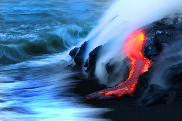 Two daredevil photographers have risked their lives to become the first people to capture the explosive moment fiery lava crashes into the sea – while in the water themselves. Fearless duo Nick Selway, 28, and pal CJ Kale, 35, brave baking hot 110F (43,3C) waters to snap the amazing images – standing just feet away from scalding heat and floating lava bombs. (Photo by Nick Selway/CJ Kale/Caters News Agency)