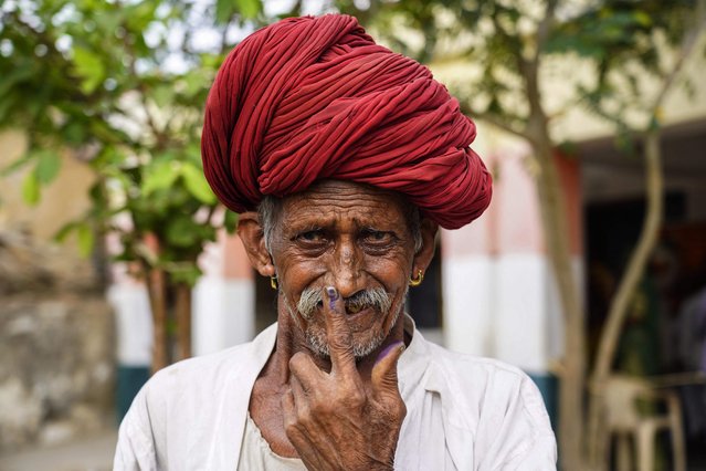 A man shows his inked finger after casting his ballot at a polling station during the second phase of voting of India's general elections in Masuda, Rajasthan state, on April 26, 2024. (Photo by Himanshu Sharma/AFP Photo)