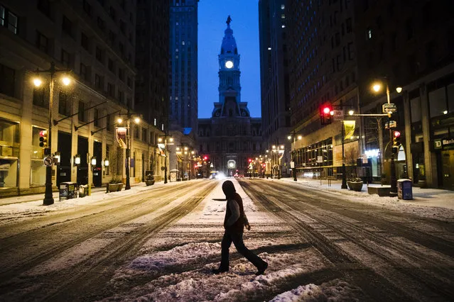 A man crosses South Broad Street in view of City Hall during a winter storm in Philadelphia, Tuesday, March 14, 2017. (Photo by Matt Rourke/AP Photo)