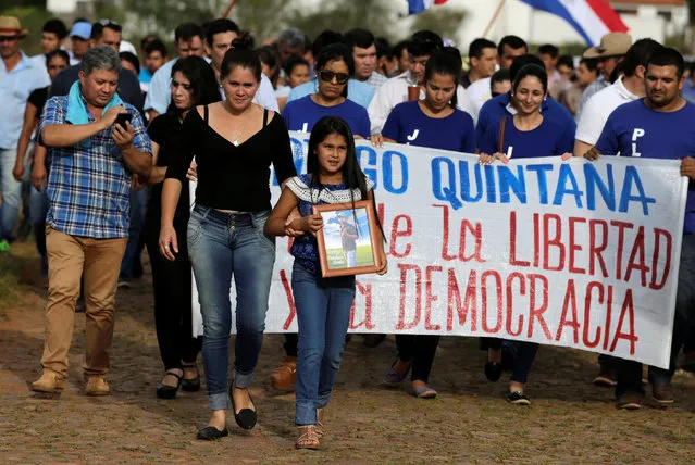 Luz, (3rd L), daughter of Rodrigo Quintana, who was killed by a rubber bullet fired by the police in the headquarters of the Liberal Party after clashes, carries a photo during her father's funeral in La Colmena, Paraguay, April 2, 2017. The poster says “Rodrigo Quintana, Martyr of Freedom and Democracy”. (Photo by Jorge Adorno/Reuters)