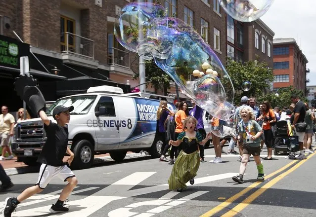 Children chase giant balloons on the streets of the Gas Lamp District on opening day of the 2015 Comic-Con International convention Thursday, July 9, 2015, in San Diego. (Photo by Lenny Ignelzi/AP Photo)