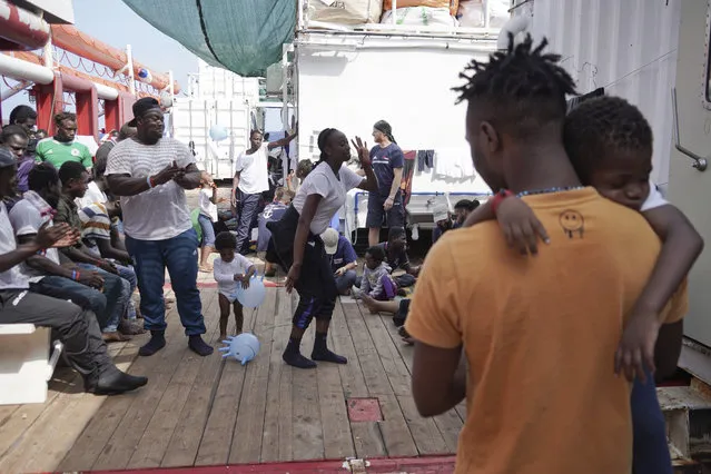 Rescued migrants dance and sing on the deck of the Ocean Viking as it sails in the Mediterranean Sea, Saturday, September 21, 2019. The humanitarian ship operated by SOS Mediterranee and Doctors Without Borders is still waiting to be assigned a place of safety to disembark 182 people rescued after fleeing Libya. (Photo by Renata Brito/AP Photo)
