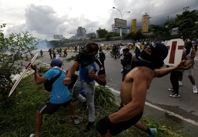Demonstrators throw stones during a rally against Venezuela's President Nicolas Maduro in Caracas, Venezuela on May 2, 2017. (Photo by Marco Bello/Reuters)