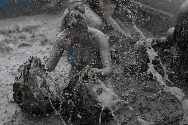Festival-goers wrestle in the mud during the annual Boryeong Mud Festival at Daecheon Beach on July 18, 2015 in Boryeong, South Korea. (Photo by Chung Sung-Jun/Getty Images)