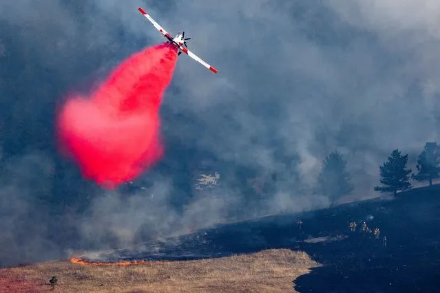 An air tanker drops slurry on the NCAR Fire on March 26, 2022 in Boulder, Colorado. The wildfire, which has forced almost 20,000 people to evacuate their homes, started just a few miles away from where the Marshall Fire destroyed more than 1,000 homes in December. (Photo by Michael Ciaglo/Getty Images)