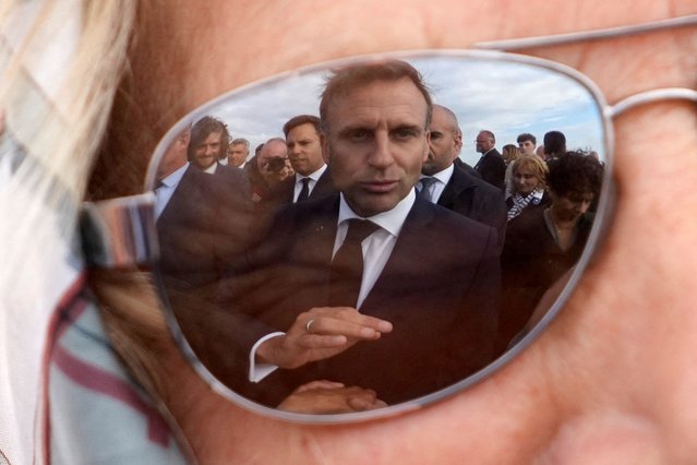 French President Emmanuel Macron is reflected on a resident's glasses on the day of a ceremony commemorating Charles de Gaulle's World War II resistance call of June 18, 1940, on the Ile de Sein, France on June 18, 2024. (Photo by Christophe Ena/Pool via Reuters)