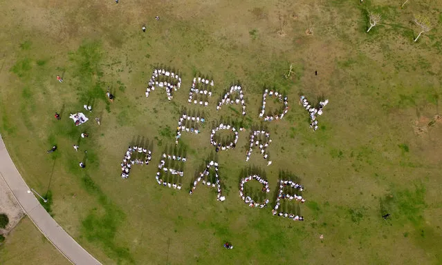 A photo taken with a drone on May 18, 2017 shows women from the “Women Wage Peace” (WWP) group in Midoun Park in the Israeli Mediterranean coastal city of Tel Aviv holding up pieces of cardboard in formation to read “Ready for Peace” in support of the US President' s declarations to do all he can to re- start the peace process when he arrives in Israel next week. (Photo by Jack Guez/AFP Photo)