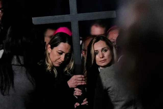 Two nurses, Albina from Russia, right, and Irina, from Ukraine hold the cross as they take part in the Via Crucis (Way of the Cross) torchlight procession presided by Pope Francis on Good Friday in front of Rome's Colosseum, in Rome, Friday, April 15, 2022. (Photo by Gregorio Borgia/AP Photo)