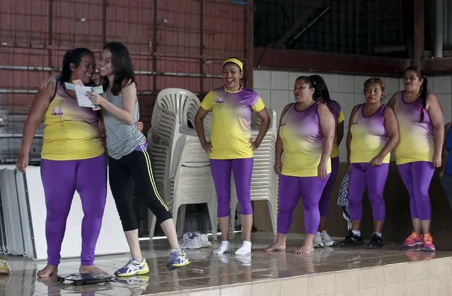 Andrea Abarca (R) congratulates Hazel Castillo after announcing that she lost 7 kilograms, before an aerobics class in Los Guidos de Desamparados July 23, 2015. Castillo lost 7 kilograms in six months while participating in the health program organized by Abarca, which aims to combat obesity and sedentary behavior in poor women living in a slum. (Photo by Juan Carlos Ulate/Reuters)